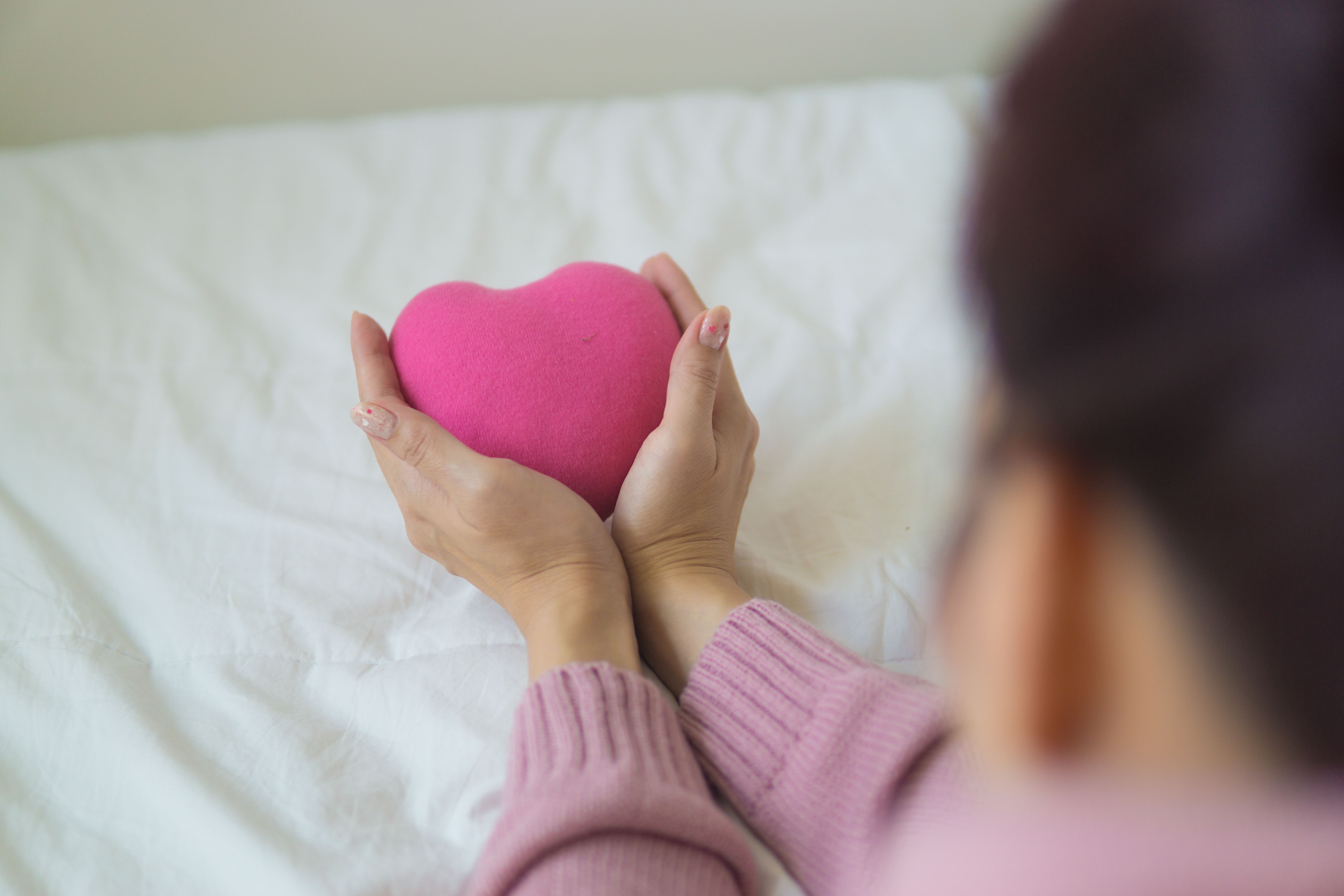 Woman holding a pink plush love heart in her hands