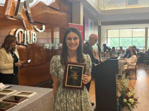 Member of the REHAB Lab posing with her award