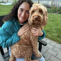 Woman in a blue jacket posing with a dog